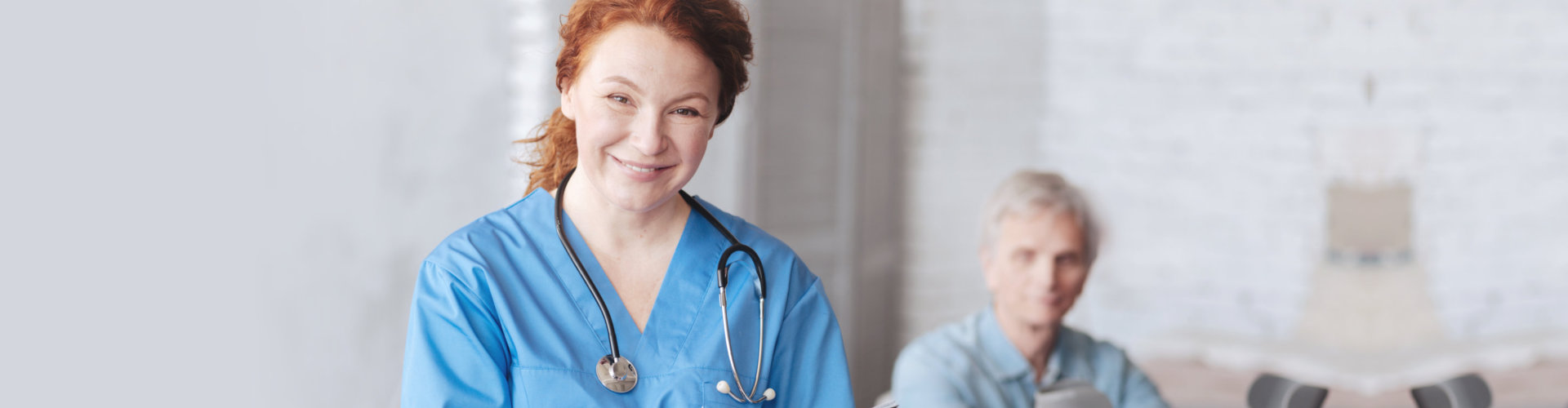optimistic nurse smiling in front on senior patient